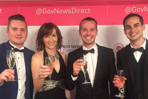 Photo of Jo and colleagues at the @GovNewsDirect awards. The group are all smartly dressed and holding up glasses of champagne. Theyre standing in front of a banner which says @GovNewsDirect