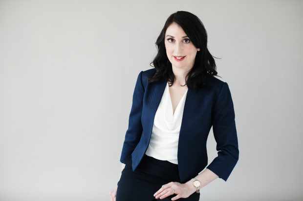 Professional photo of Kate. She has shoulder length black hair and is wearing a navy jacket with a white shirt.