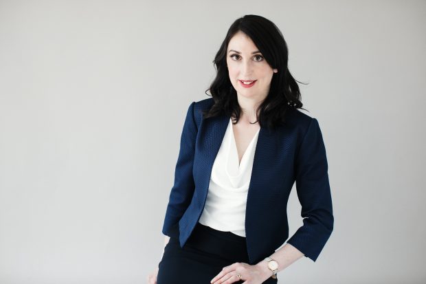 Professional photo of Kate. She has shoulder length black hair and is wearing a navy jacket with a white shirt.
