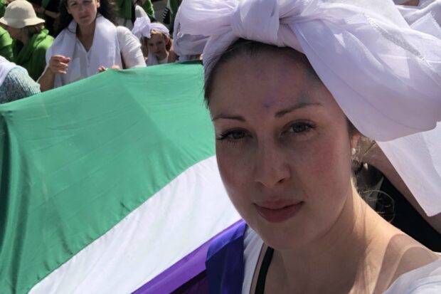 Siobhan Sherry at a women's march carrying the suffrage flag